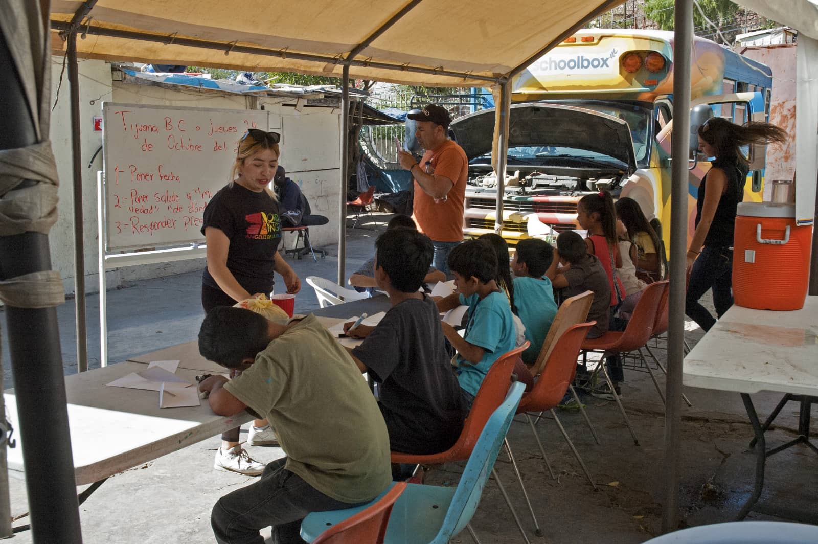 Photograph by Tish Lampert showing children taking a class in a makeshift classroom