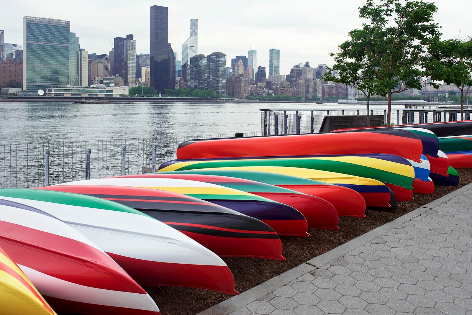 Photo of 'Convene' by Xaviera Simmons -- colorfully painted canoes lying along the East River in NYC